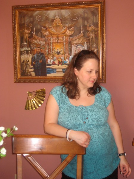 Lauren Ambrose Hughes, due around August 31, standing in front of the now-20 year old painting of the opera Turandot which I painted for late David Ambrose.i 